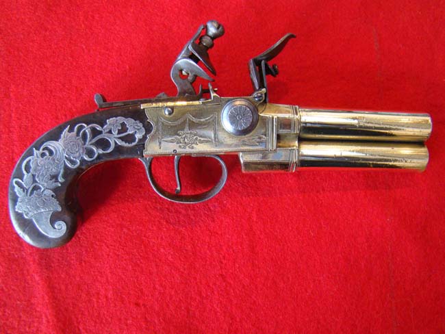 A fine late 18th century English tap action over/under brass barreled flintlock pistol
